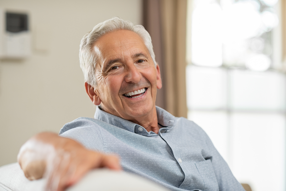 Portrait of happy senior man smiling at home